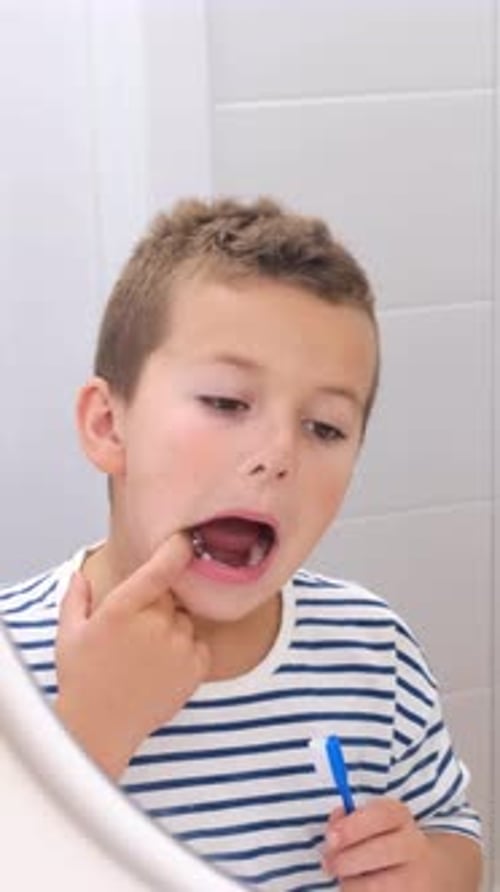 Young Boy Brushing Teeth in Bright Bathroom