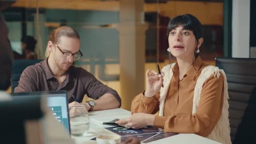 Young Female Boss Having Talk with Colleague on Meeting in Office