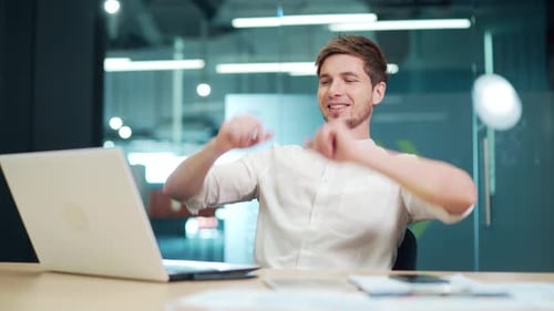 Employee stretching while taking a break at desk job at modern office. Workplace holding hands behin