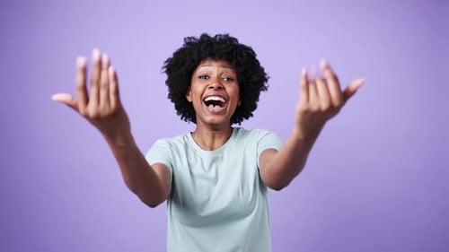 Heureuse femme afro-américaine s'embrassant sur fond violet au ralenti