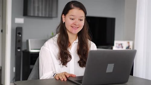 Woman uses laptop for remote video call at home