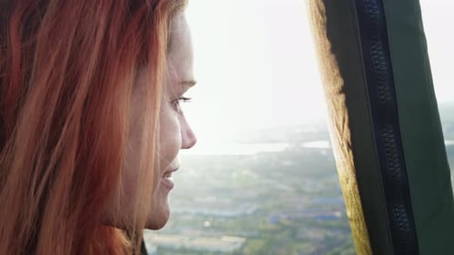 Woman Smiles, Looking out an Air Vehicle Window
