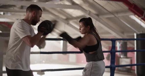Woman Boxing with Trainer in a Gym Ring
