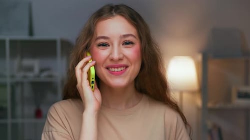 Smiling Woman Talking on Smartphone Indoors