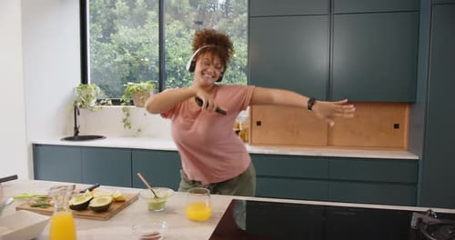 Happy Woman Dancing in Kitchen While Preparing Food