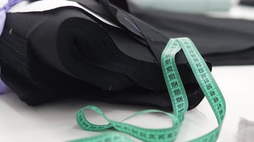 Nahaufnahme von Nähzubehör ein Zentimeter auf drapiertem Stoff