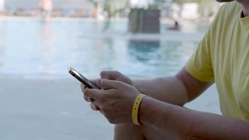 Man Using Cell Phone By Pool