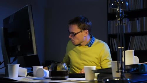 Man in Eyeglasses Working Overtime in Office