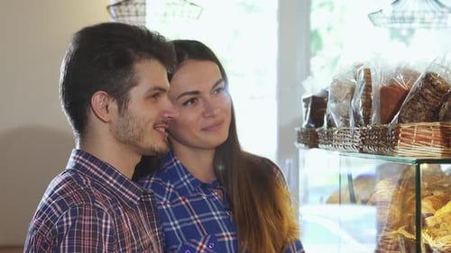 Charming Couple Selecting Delectable Desserts at a Cozy Bakery