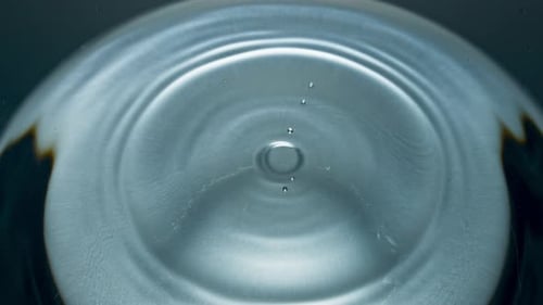 Water Drop Creates Ripples on Surface in Close-Up
