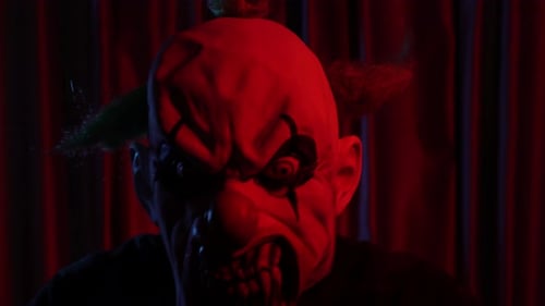 Close Up of Scary Evil Clown in Dark Room with Red Lights