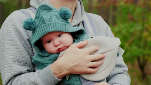 Young Father with His Newborn Baby in a Sling Walking in the Autumn Forest The Concept of a Happy