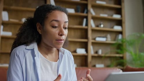 Young Woman Talking in Front of Bookcase Indoors