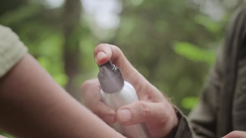 Applying Bug Spray in the Forest