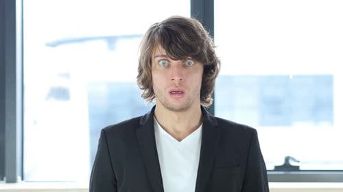 Surprised Young Adult Man Indoors Looking at Camera