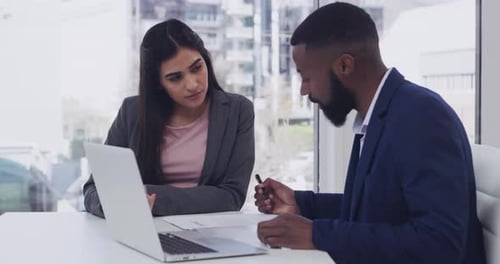 4k video footage of two businesspeople sitting with a laptop and paperwork in a office