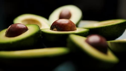 Fresh Avocado Halves Rotating on Plate