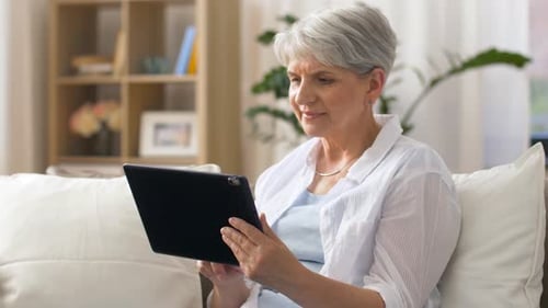 Senior Woman Relaxing at Home Using Tablet