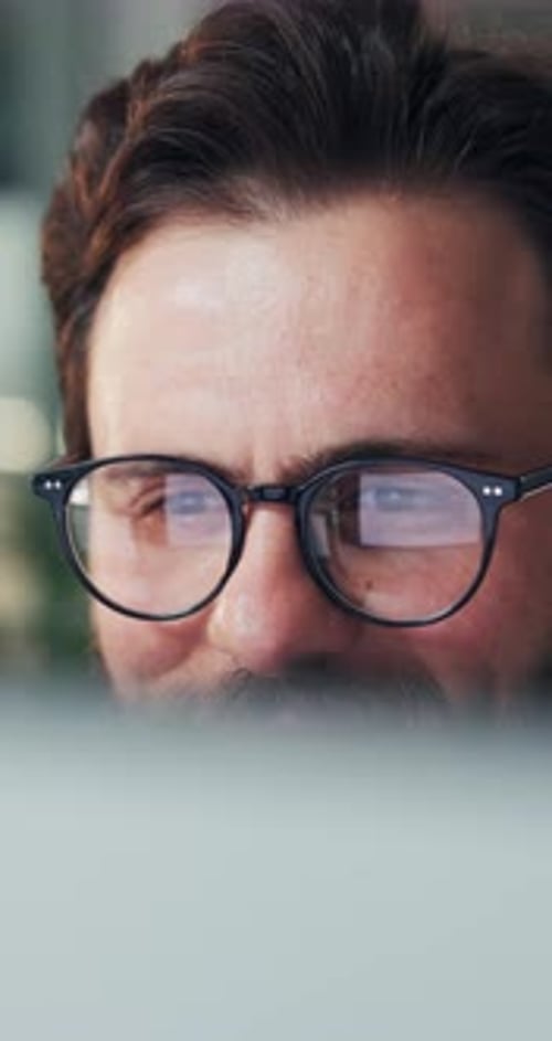 Creative, man and reading with computer in office for research, proofreading and story submission