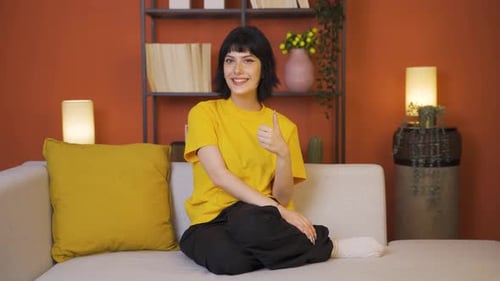 Young Woman Giving Approval Thumbs Up at Home