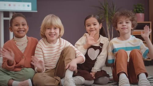 Portrait of Multicultural Elementary School Kids Waving at Camera