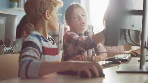 Elementary School Computer Science Classroom: Portrait of Smart Girl and Boy Talking while using Pe