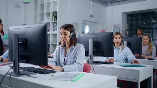 Junge erwachsene Frauen, die im CallCenter-Büro eines modernen Unternehmens arbeiten, rufen per Headset an