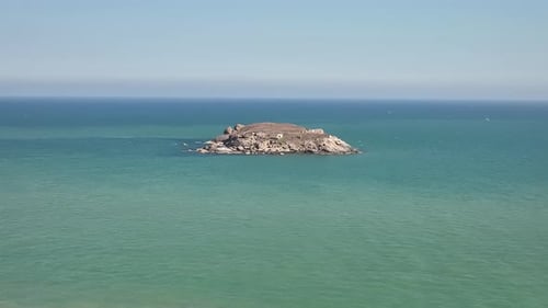 Small Rocky Island in Turquoise Ocean Aerial View
