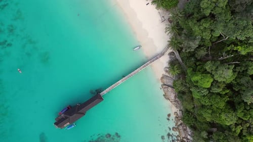 jetty pier at tropical beach, turquoise water. Spectacular aerial view flight drone