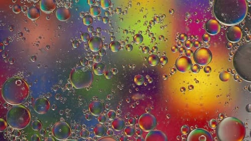 Colorful bubbles in different sizes slowly moving around on surface