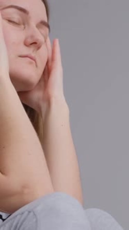 Woman Holding Head with Eyes Closed