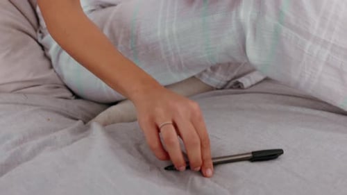 Woman Writing in a Journal on a Bed