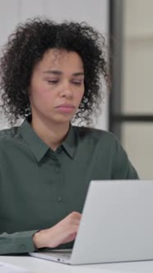 Woman Coughing While Typing on Laptop Indoors