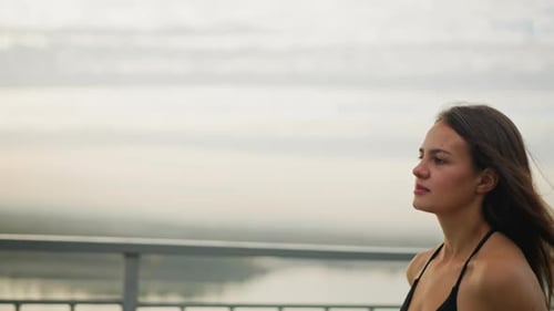 Focused Young Woman Running Outdoors in Black Singlet on Fitness Path