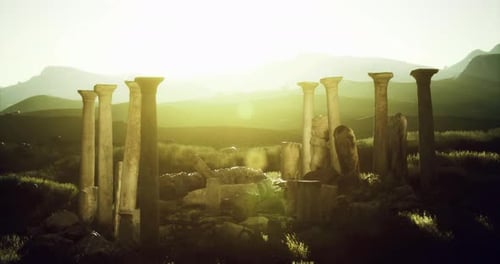 Ancient Columns Illuminated By Sunset in a Serene Landscape