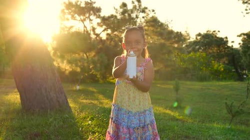 Latina girl plays with foam can in outdoor park at sunset happy and cheerful girl smiling enjoying
