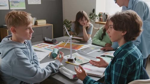 Students Collaborating on Project with Wind Turbine Model in Classroom