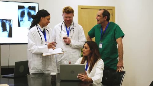 Medical Team Discussing Patient X-Rays in Office Setting