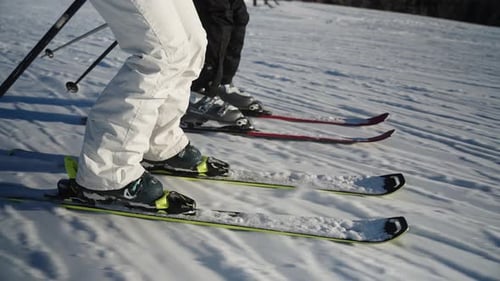 4k slow motion close up tracking side view of skis going downhill at high speed on a sunny winter da