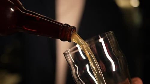 Beer Pouring from Bottle into Glass in Slow Motion