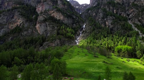 4k Drone Shot Of Long And Tall Cascading Waterfall Nestled In between Mountain Landscape With Pine T