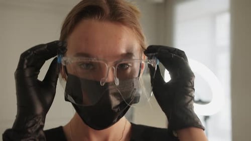 Young Adult Puts on Safety Glasses and Mask