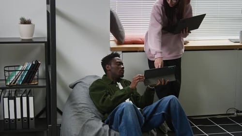 Diverse Web Developers Discussing Project Work in Startup Office