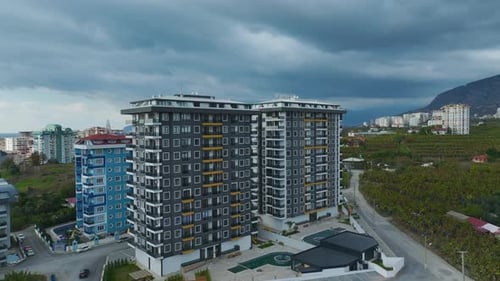Aerial Video Aerial View of a Building Facade with Dramatic Clouds in the Background
