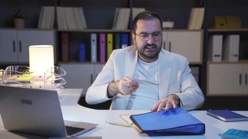 Geschäftsmann, der nachts arbeitet, ist wütend.