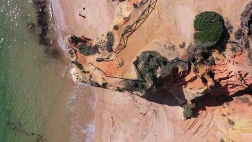 Aerial Beautiful Top View of the Beach with a Cliff and a Fence with Clear Sea Water Passersby