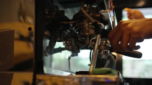 4K Barista making hot coffee on coffee maker at coffee shop.