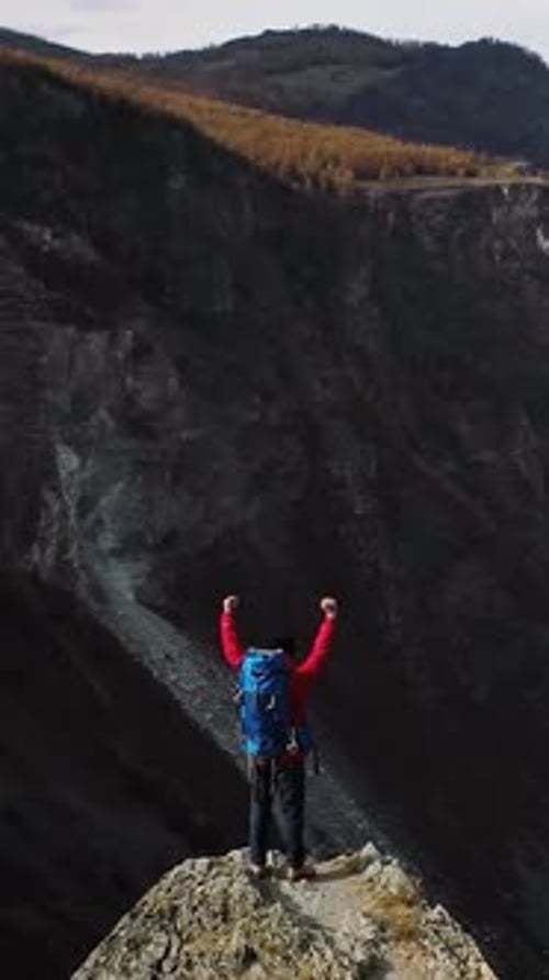 Hiker Celebrating Reaching Mountain Peak with Arms Raised