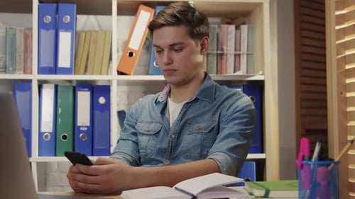 Young Man Office Manager Sitting on Break Browsing Smartphone Content News Social Media Internet at