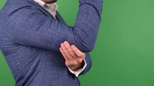 Man Rubbing Elbow in Pain on Green Screen